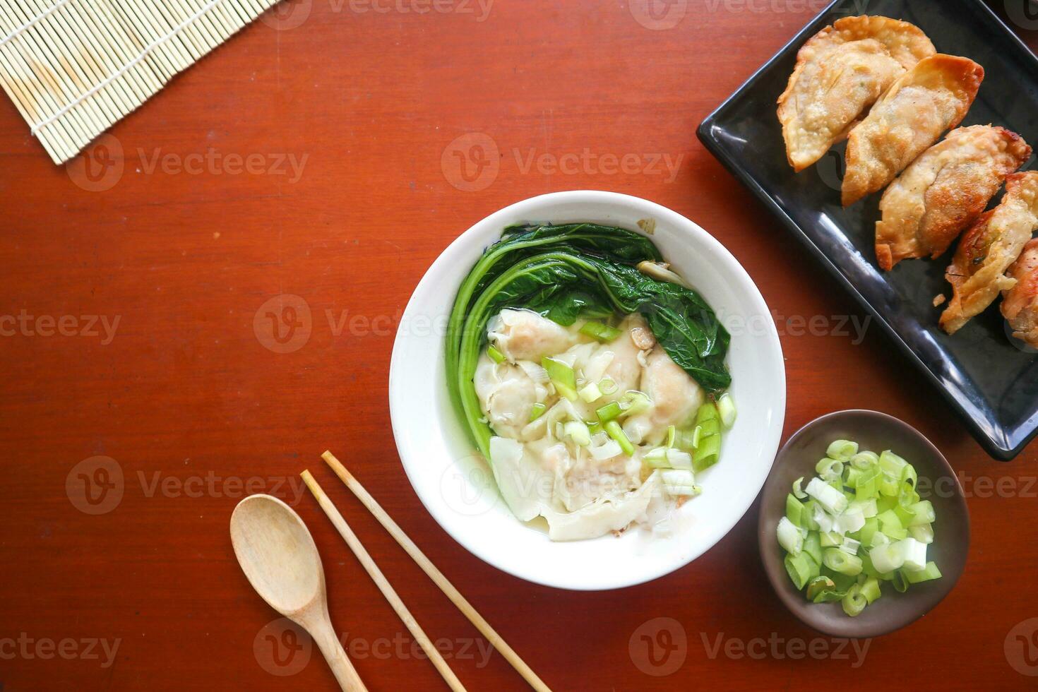 wonton soup. Bowl of wonton soup with chili oil. Shrimp or meat dumpling soup with mustard , green onions, photo