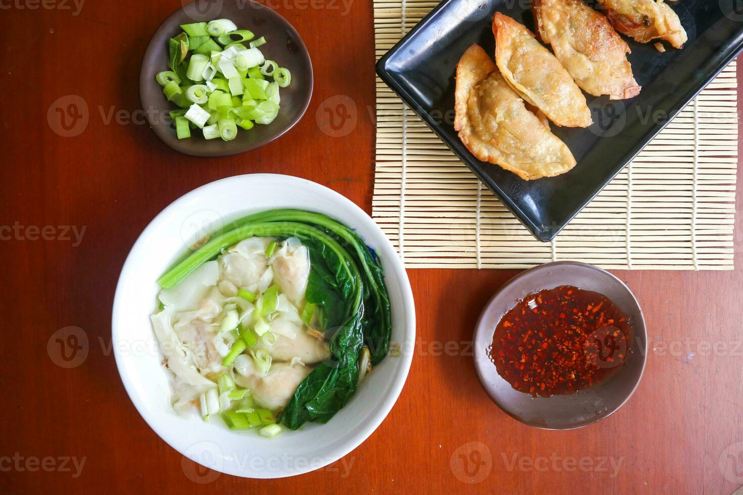 wonton soup. Bowl of wonton soup with chili oil. Shrimp or meat dumpling soup with mustard , green onions, photo
