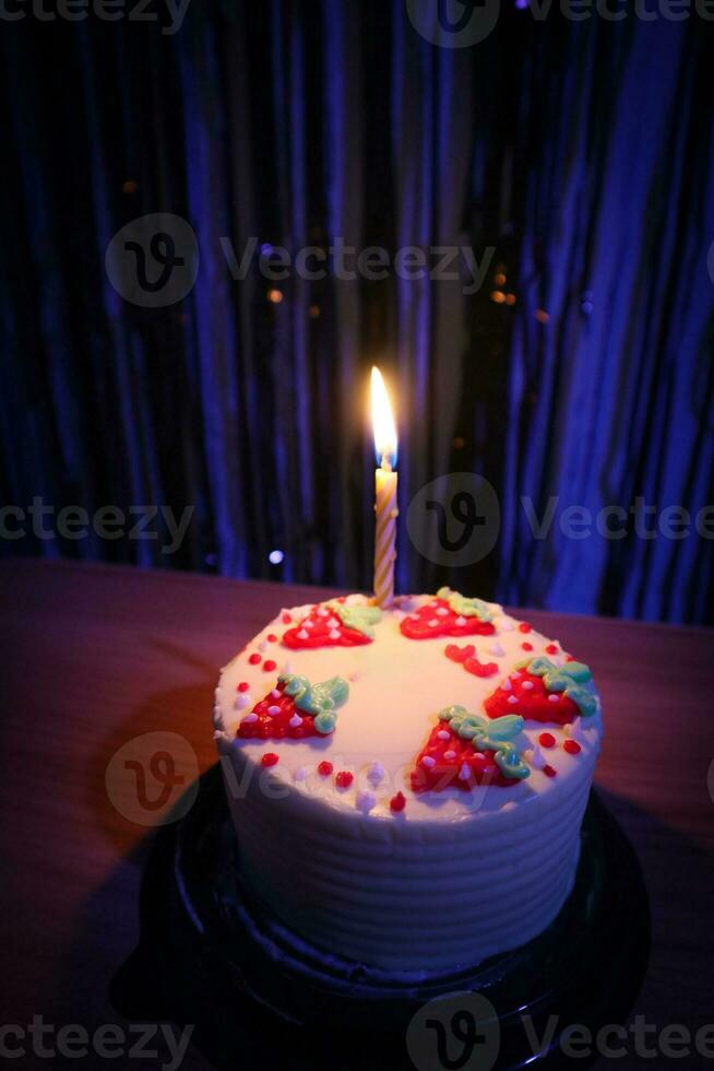 cumpleaños pastel con asperja fresa y uno velas en un azul antecedentes foto