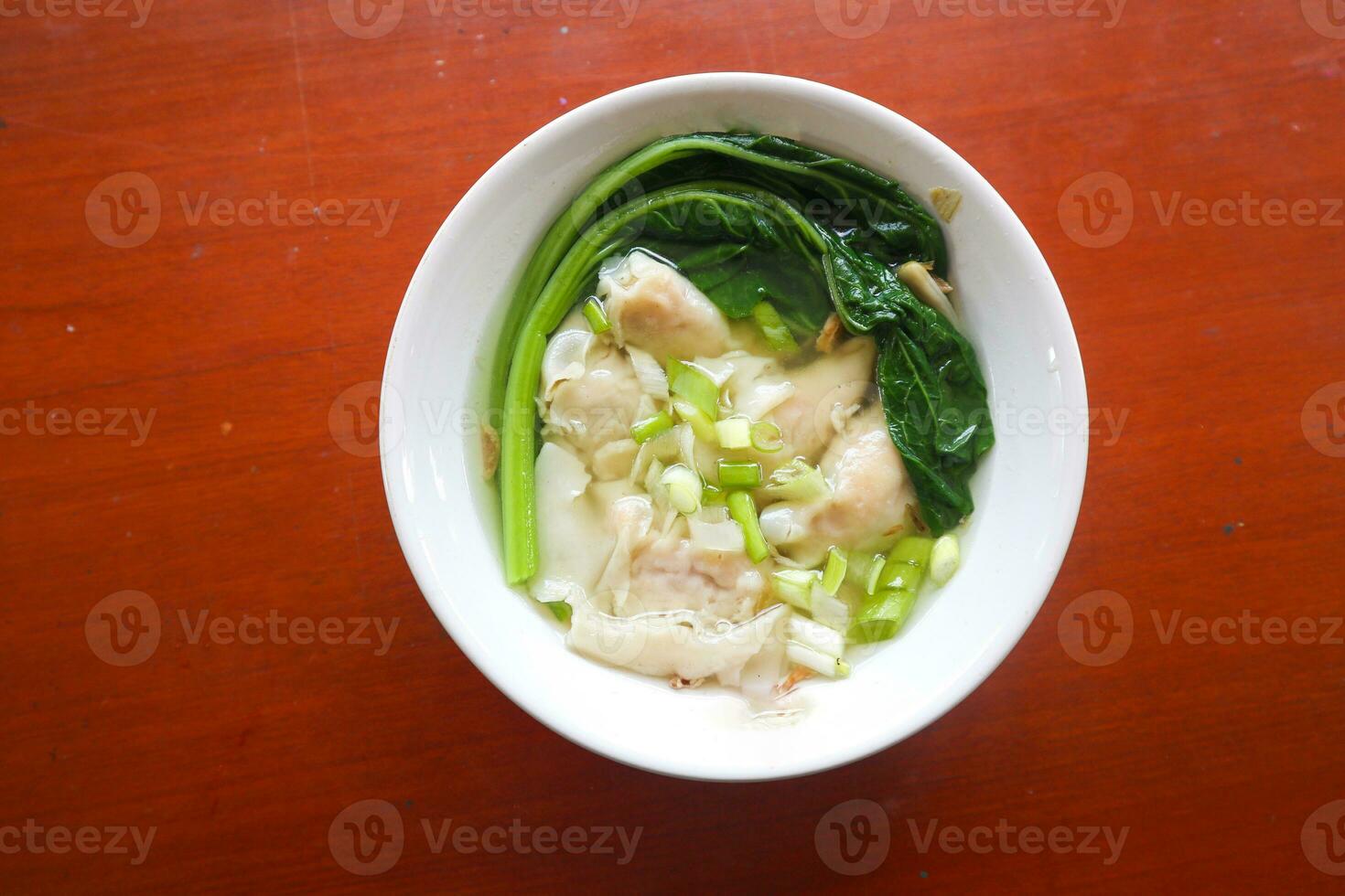 wonton soup. Bowl of wonton soup with chili oil. Shrimp or meat dumpling soup with mustard , green onions, photo