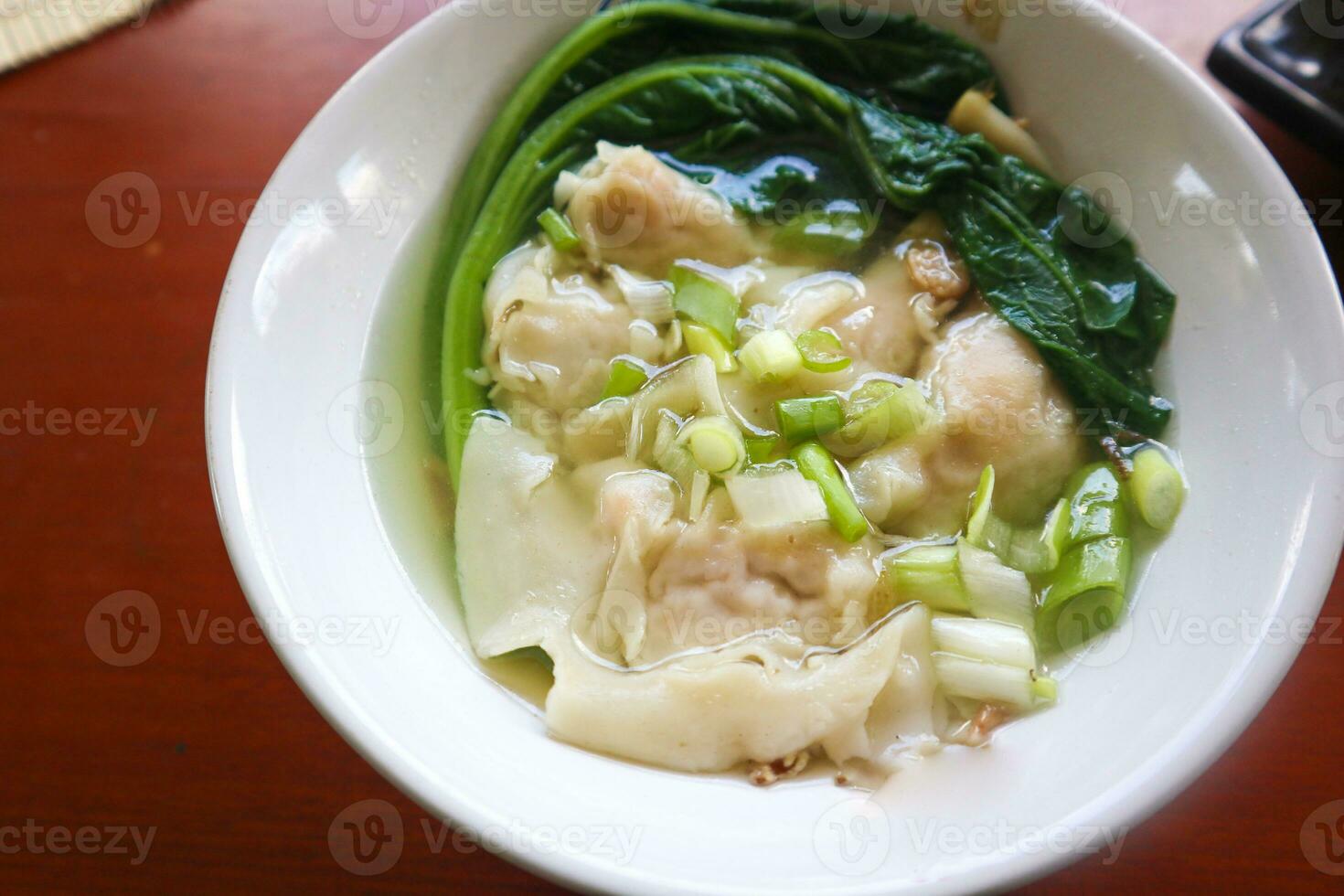 wonton soup. Bowl of wonton soup with chili oil. Shrimp or meat dumpling soup with mustard , green onions, photo