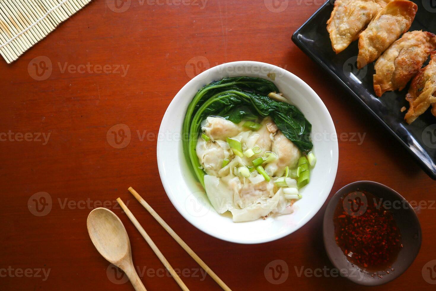 wonton soup. Bowl of wonton soup with chili oil. Shrimp or meat dumpling soup with mustard , green onions, photo