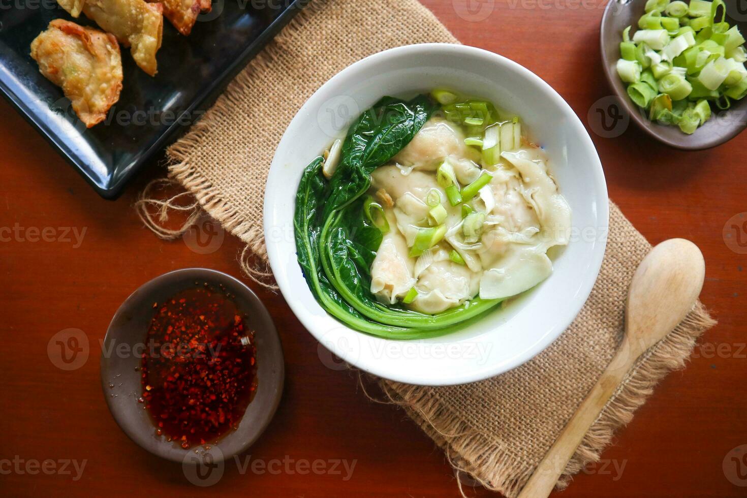 wonton soup. Bowl of wonton soup with chili oil. Shrimp or meat dumpling soup with mustard , green onions, photo