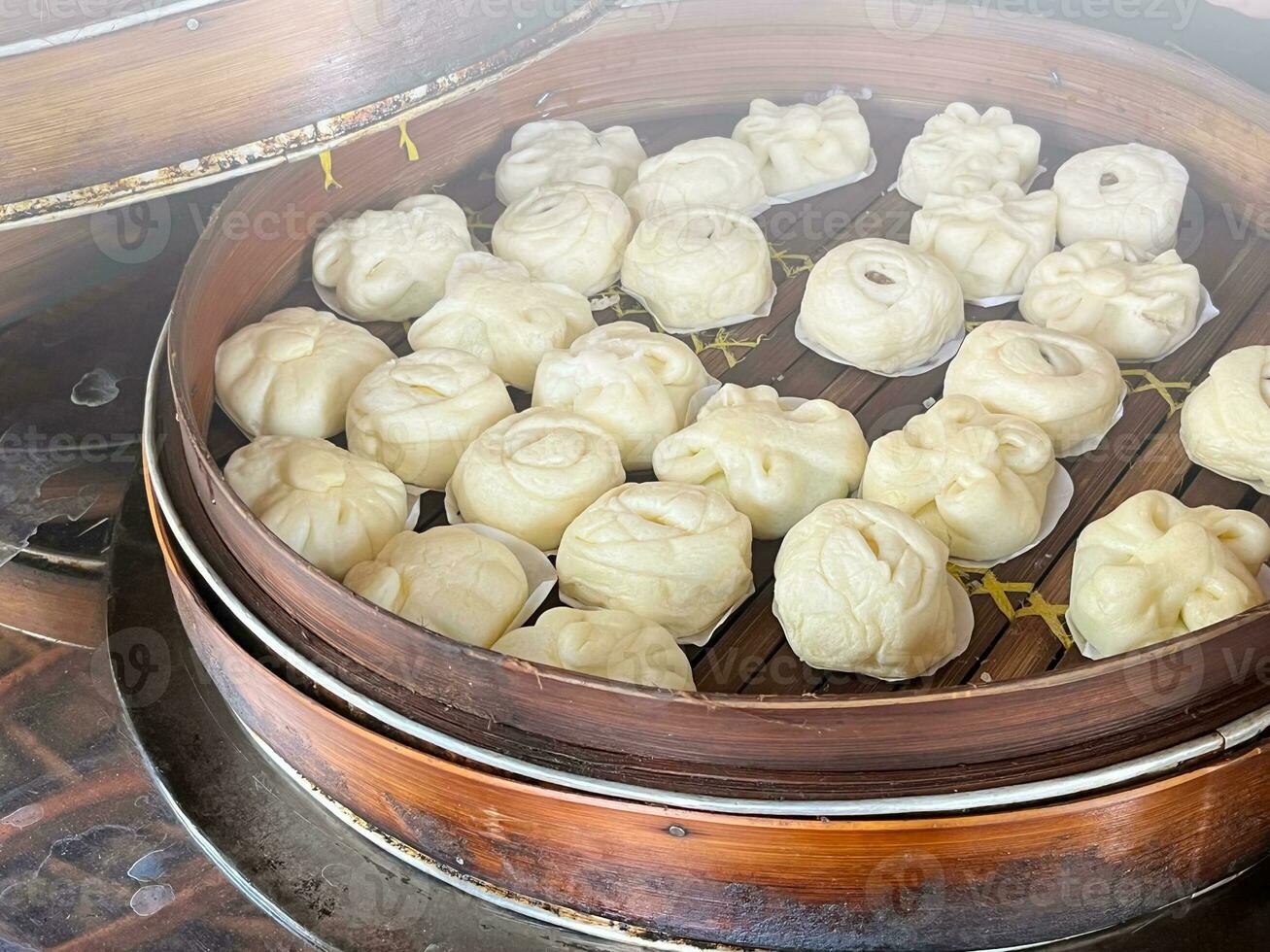 Bakpao, Baozi Steamed bun, pao, dim sum on In a bamboo steamer. a type of yeast-leavened filled bun in various Chinese cuisines. photo