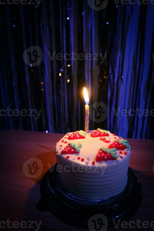birthday cake with sprinkles strawberry and one candles on a blue background photo