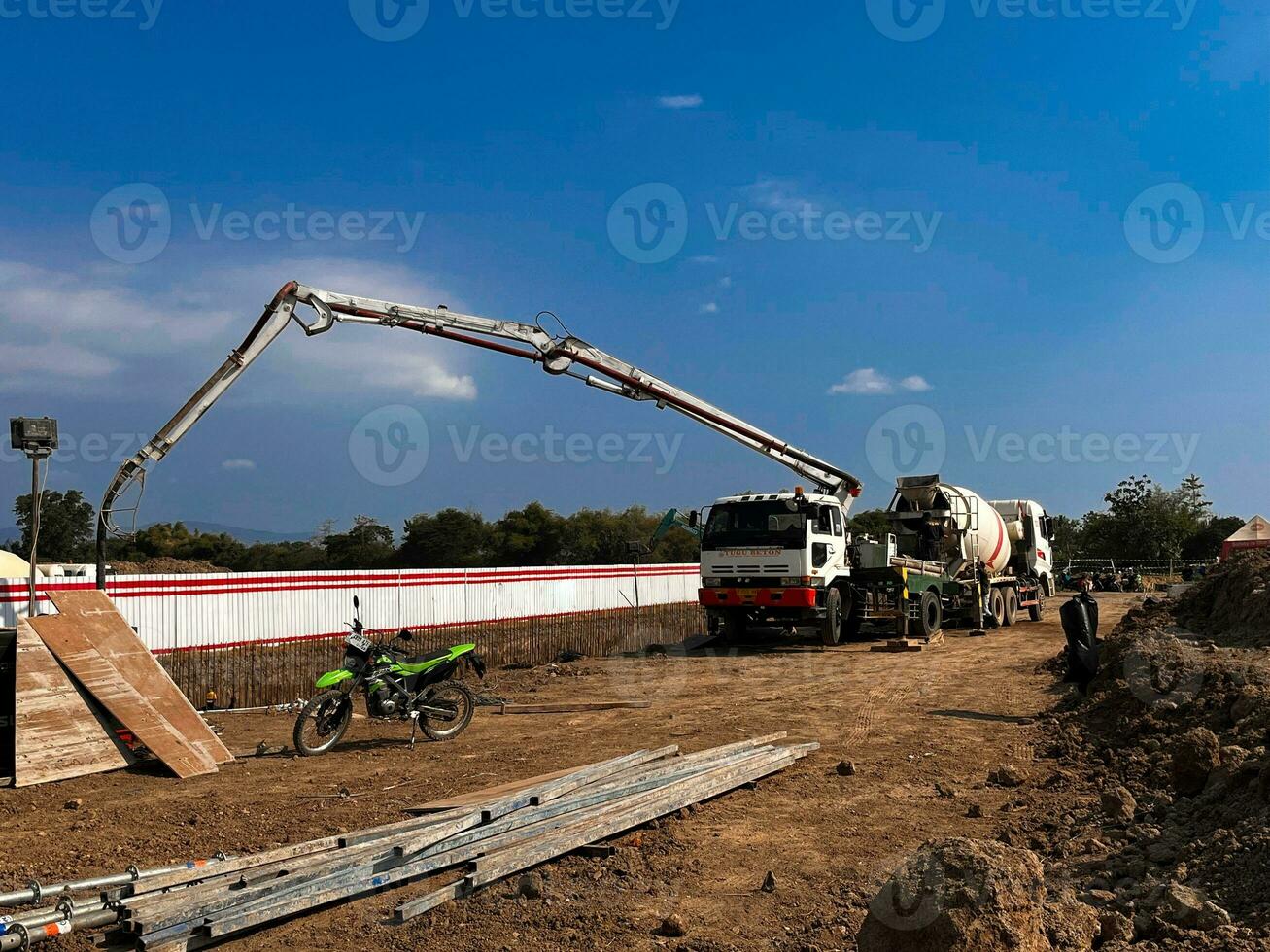 casting concrete using a Mixer Truck then using a concrete pump to push the processed concrete liquid from the mixer truck photo