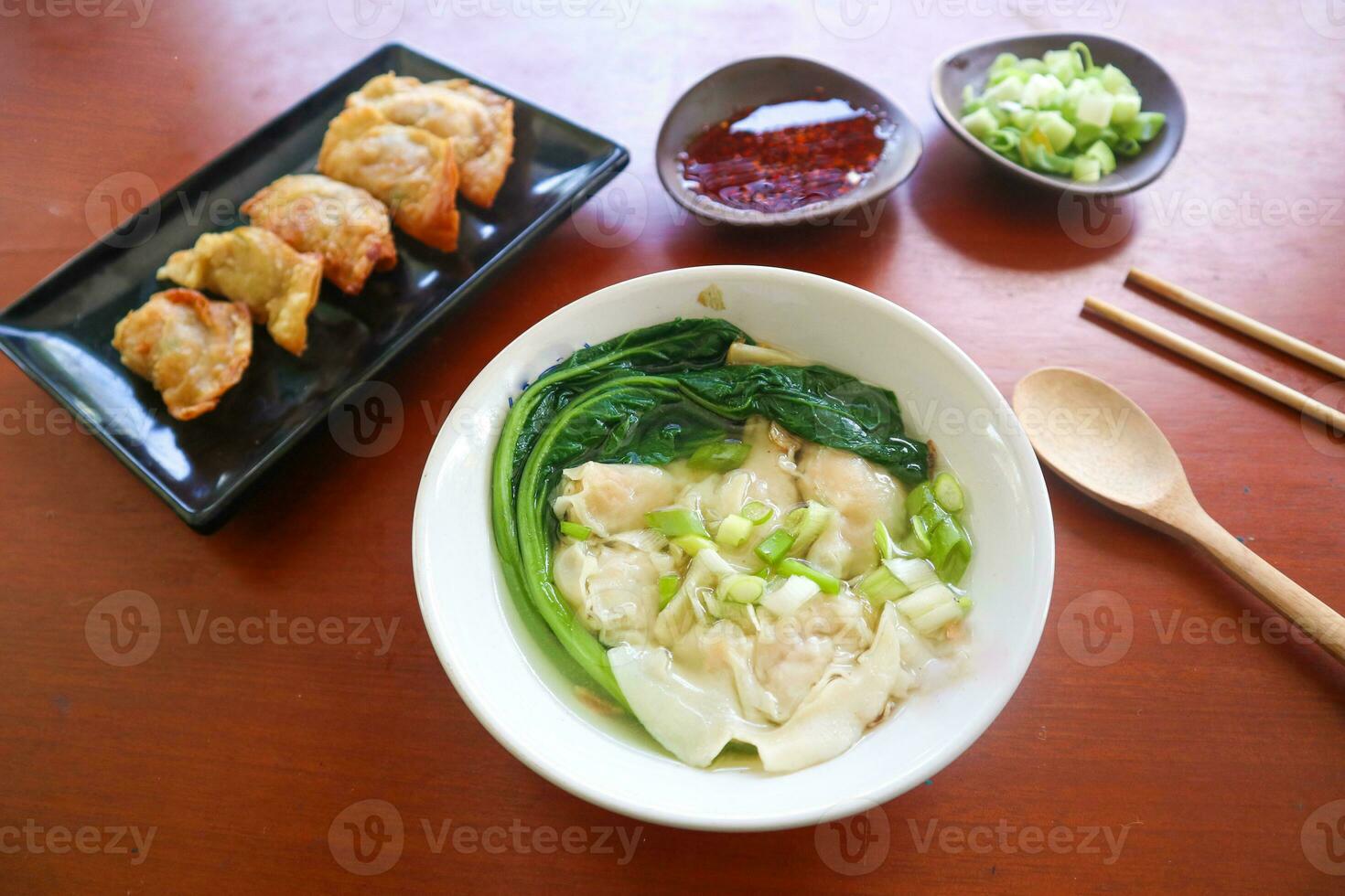 wonton soup. Bowl of wonton soup with chili oil. Shrimp or meat dumpling soup with mustard , green onions, photo