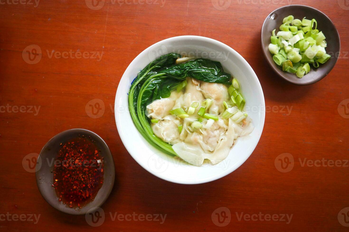 wonton soup. Bowl of wonton soup with chili oil. Shrimp or meat dumpling soup with mustard , green onions, photo