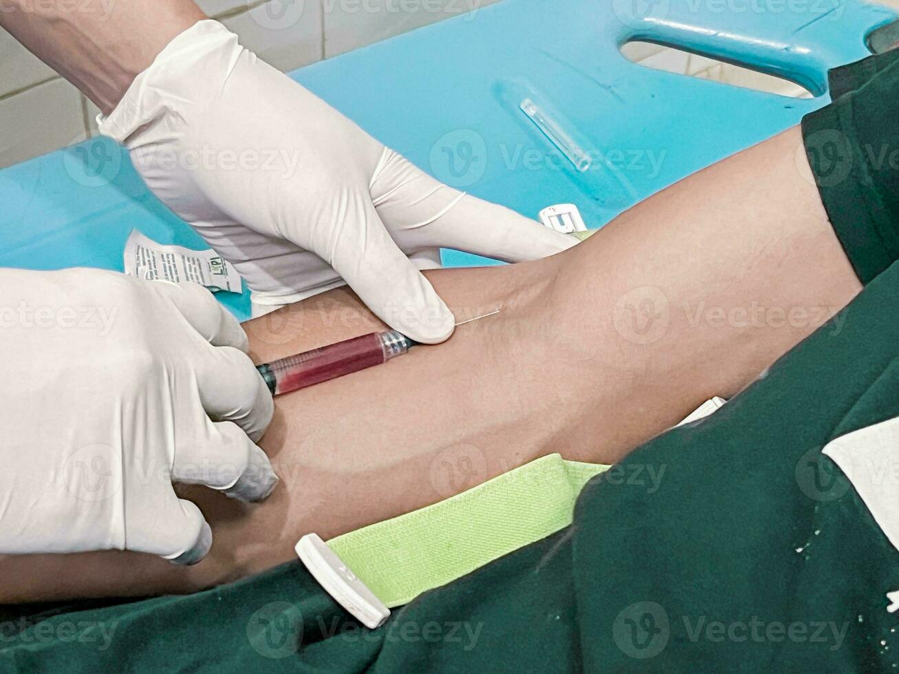 A male nurse is injecting a pain reliever anesthetic into a patient's hand photo