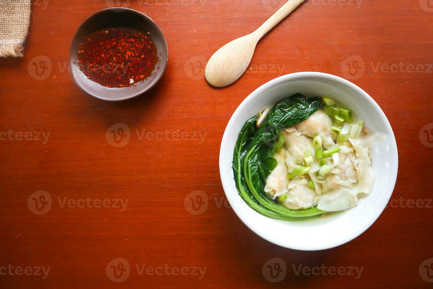 wonton soup. Bowl of wonton soup with chili oil. Shrimp or meat dumpling soup with mustard , green onions, photo