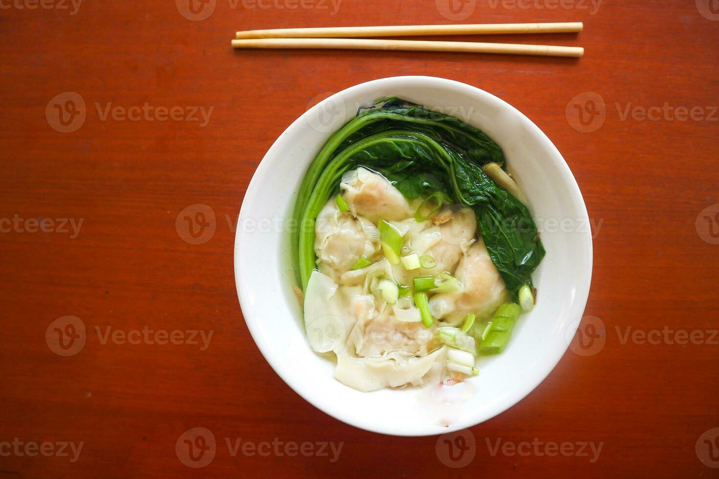 wonton soup. Bowl of wonton soup with chili oil. Shrimp or meat dumpling soup with mustard , green onions, photo