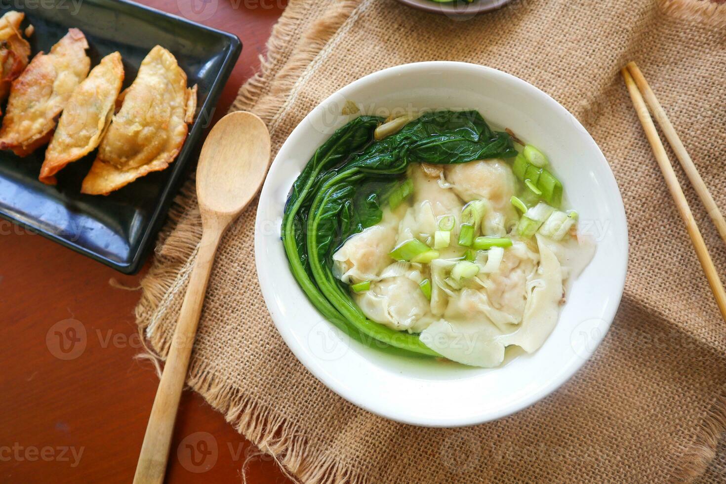 wonton soup. Bowl of wonton soup with chili oil. Shrimp or meat dumpling soup with mustard , green onions, photo