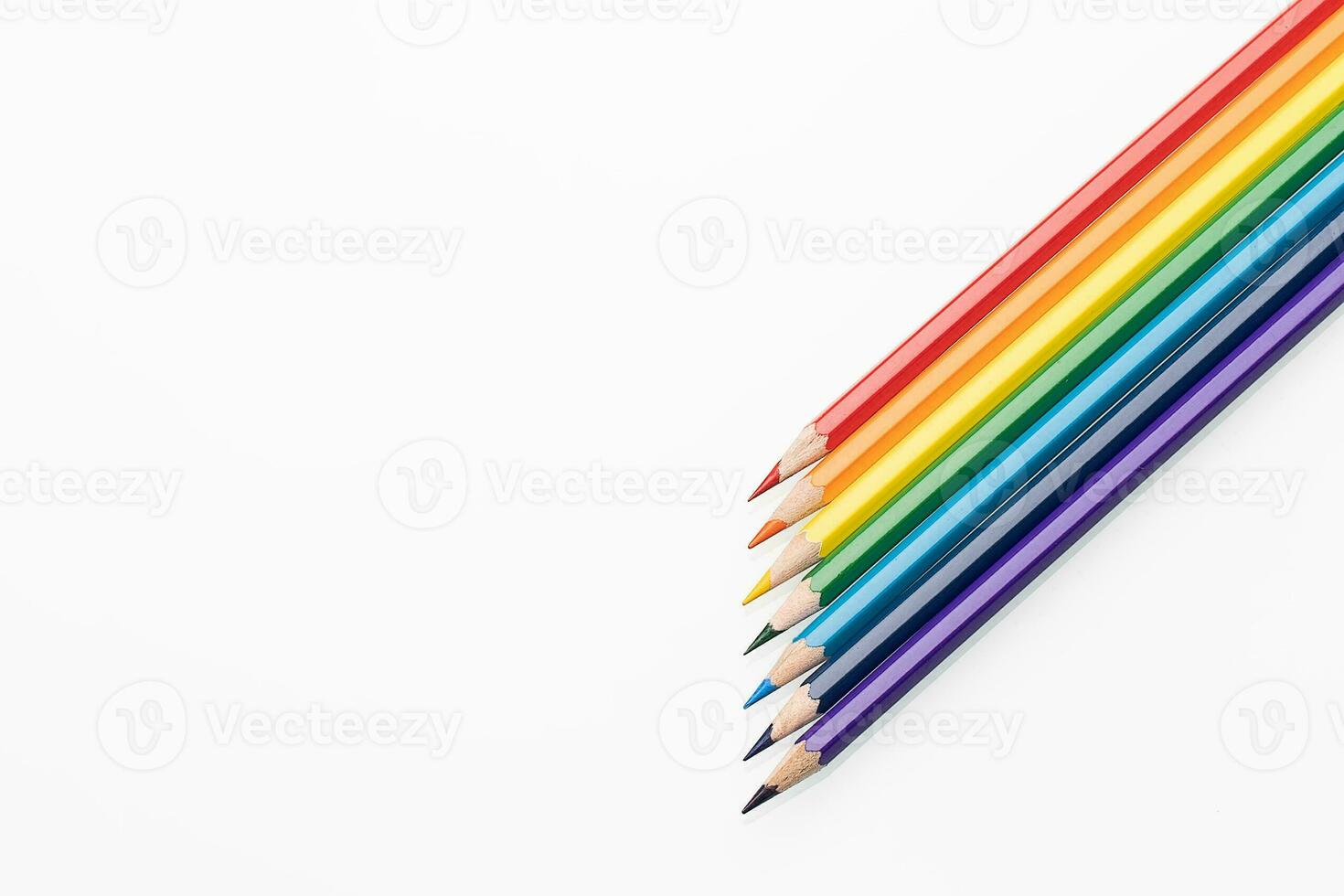 Rainbow color pencils in the form of an arrow from the right corner top view photo