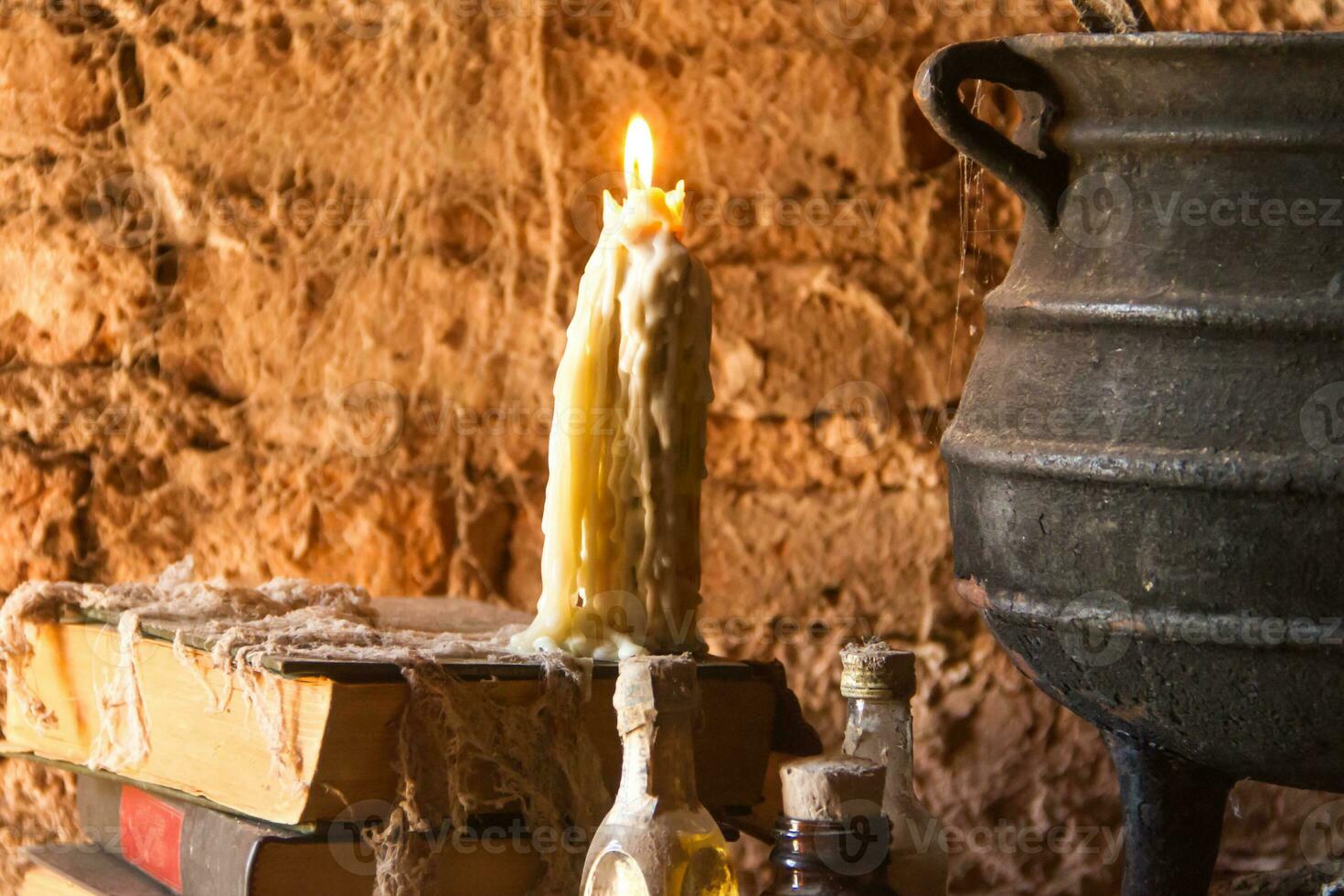 spell of witch night with candles and pot with fire between cobwebs and ancient earth photo