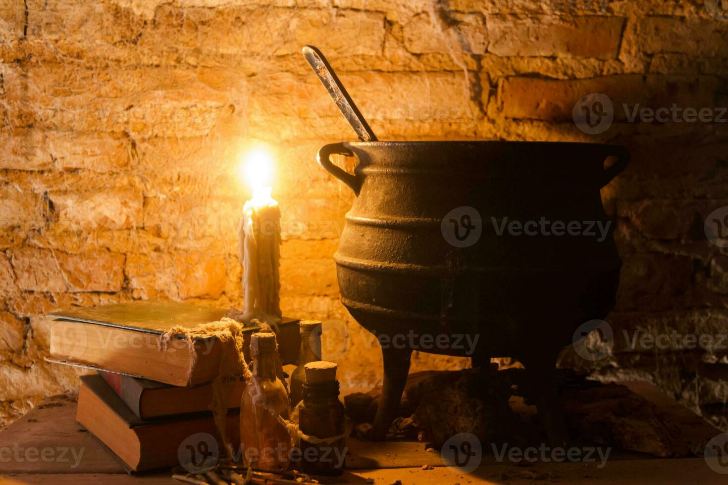 spell of witch night with candles and pot with fire between cobwebs and ancient earth photo