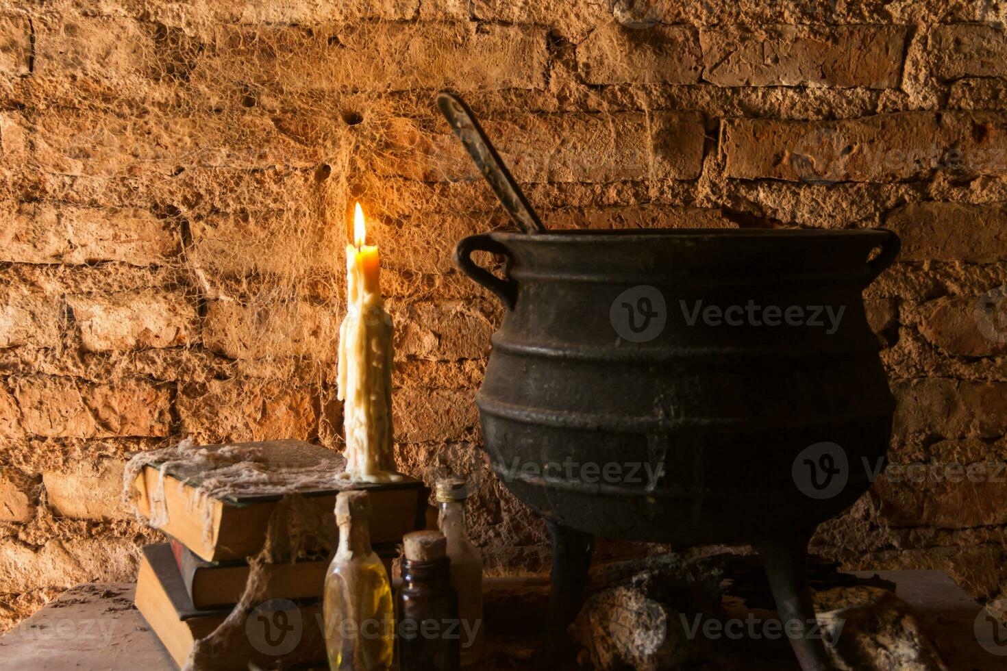 spell of witch night with candles and pot with fire between cobwebs and ancient earth photo