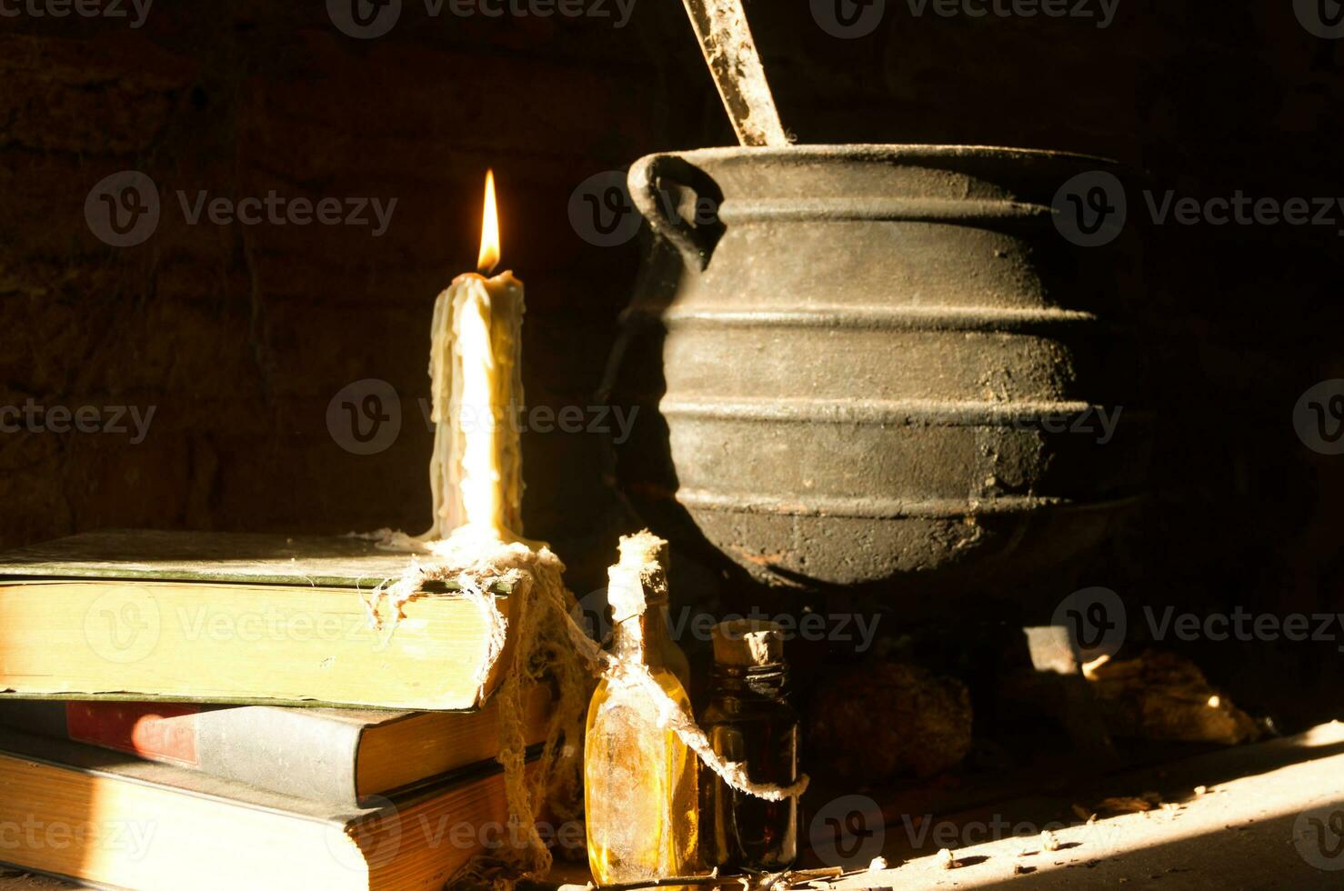 spell of witch night with candles and pot with fire between cobwebs and ancient earth photo