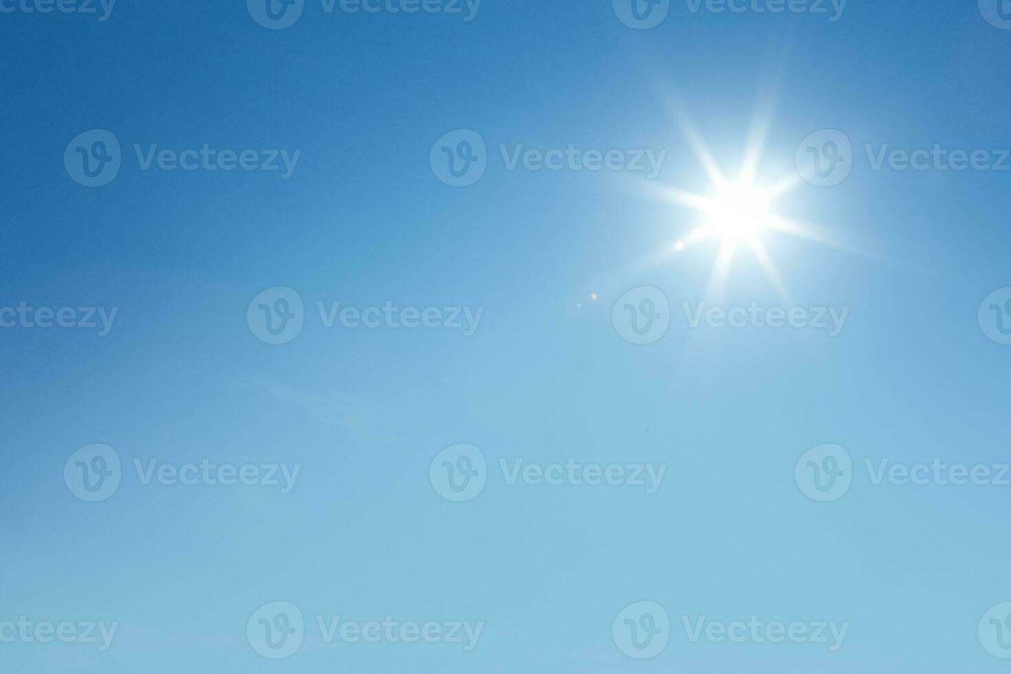 The sun during the day has a background of a blue sky. photo