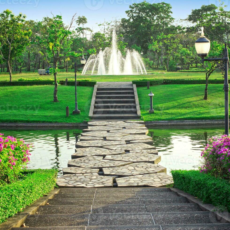 Stone walkway in a park with a fountain photo