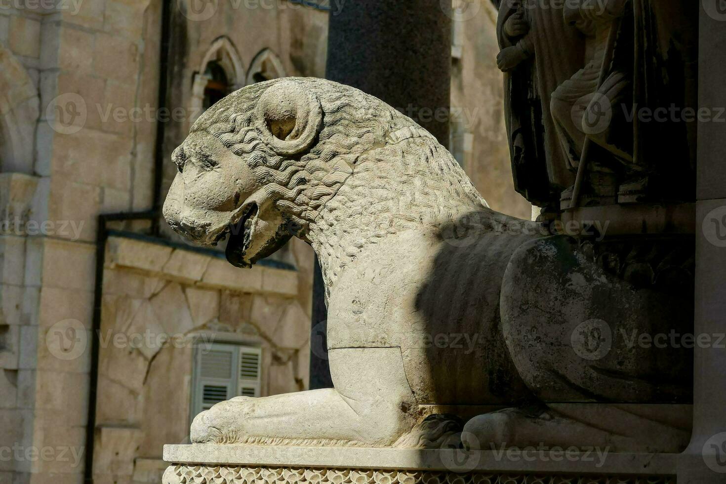 a statue of a lion sitting on a pillar photo