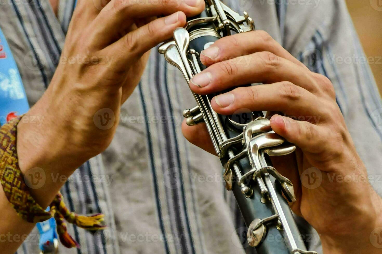 a man is playing a clarinet with his hands photo