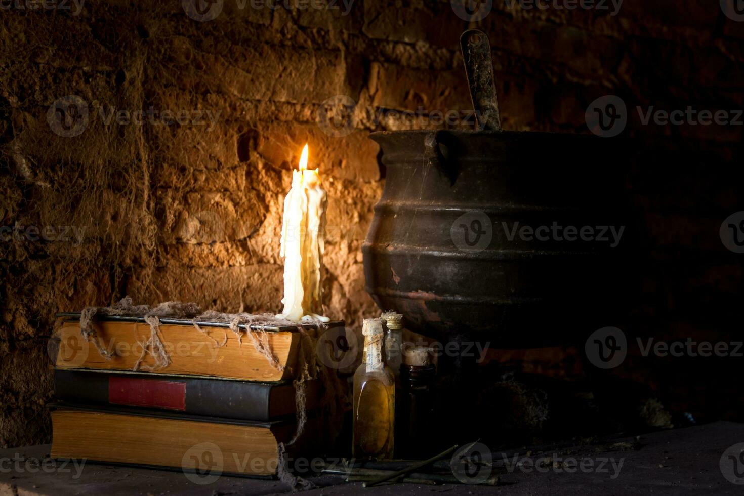spell of witch night with candles and pot with fire between cobwebs and ancient earth photo