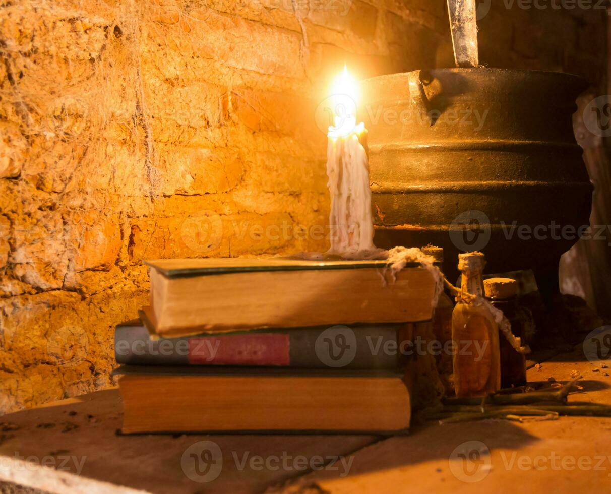 spell of witch night with candles and pot with fire between cobwebs and ancient earth photo