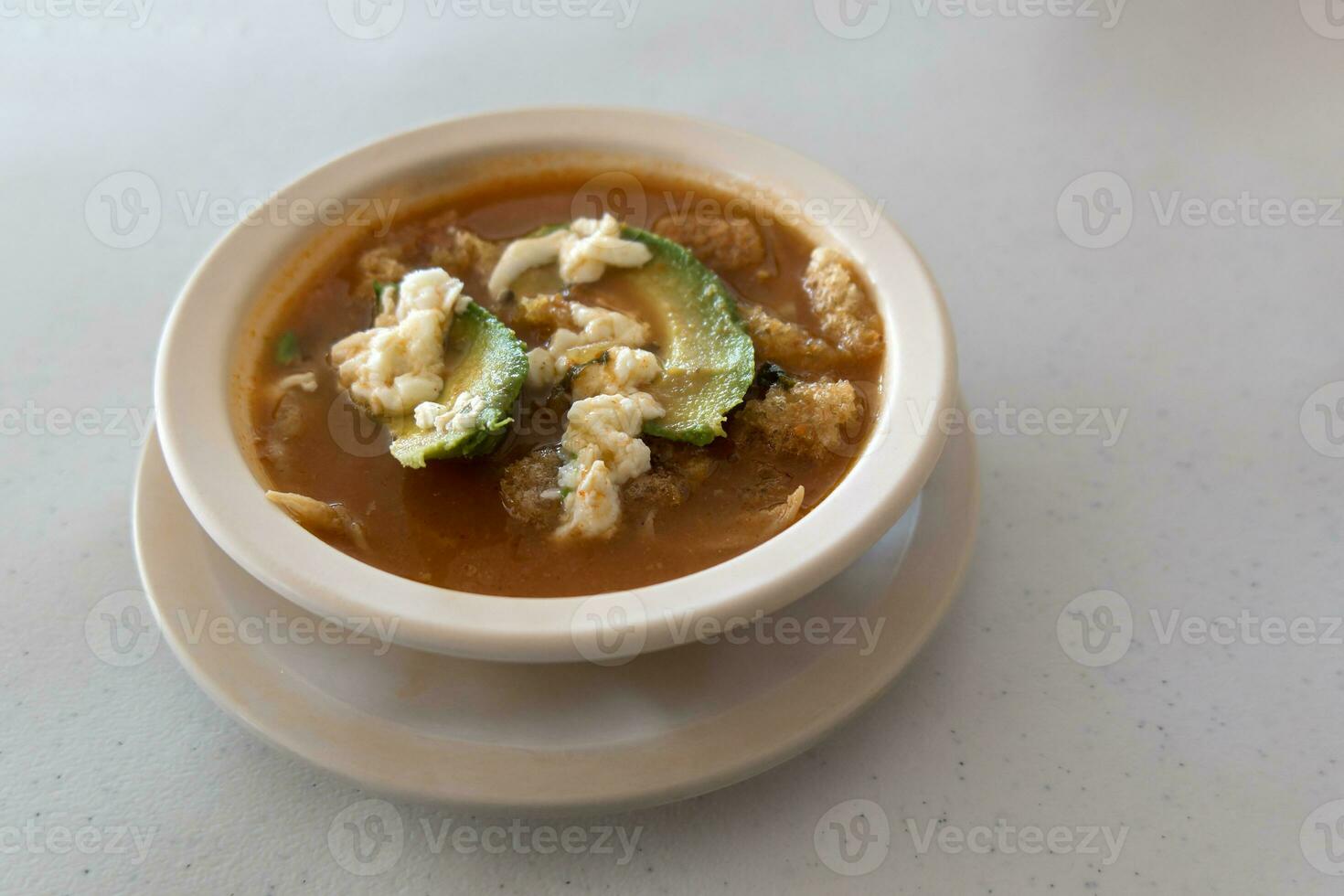 Mexican aztec soup with chicharron avocado cheese and tortilla photo