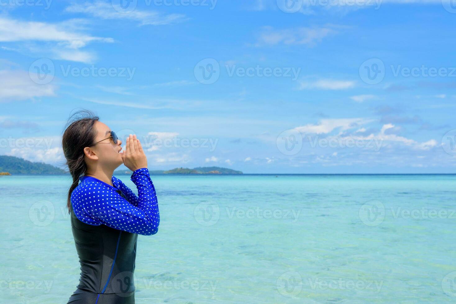 Asian woman shouting with hands on the sea in summer, Thailand photo