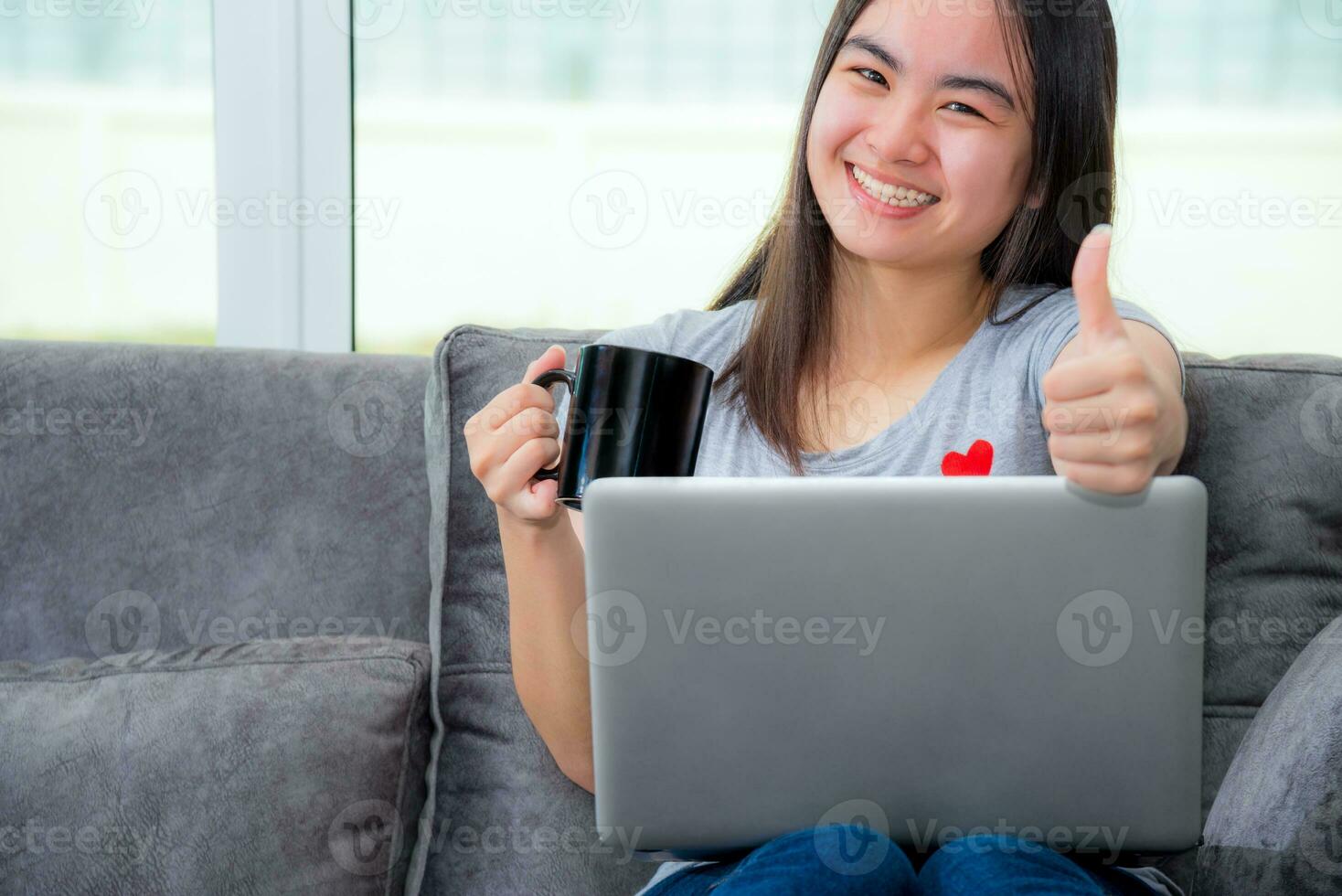 Woman holding coffee cup show thumb in work photo