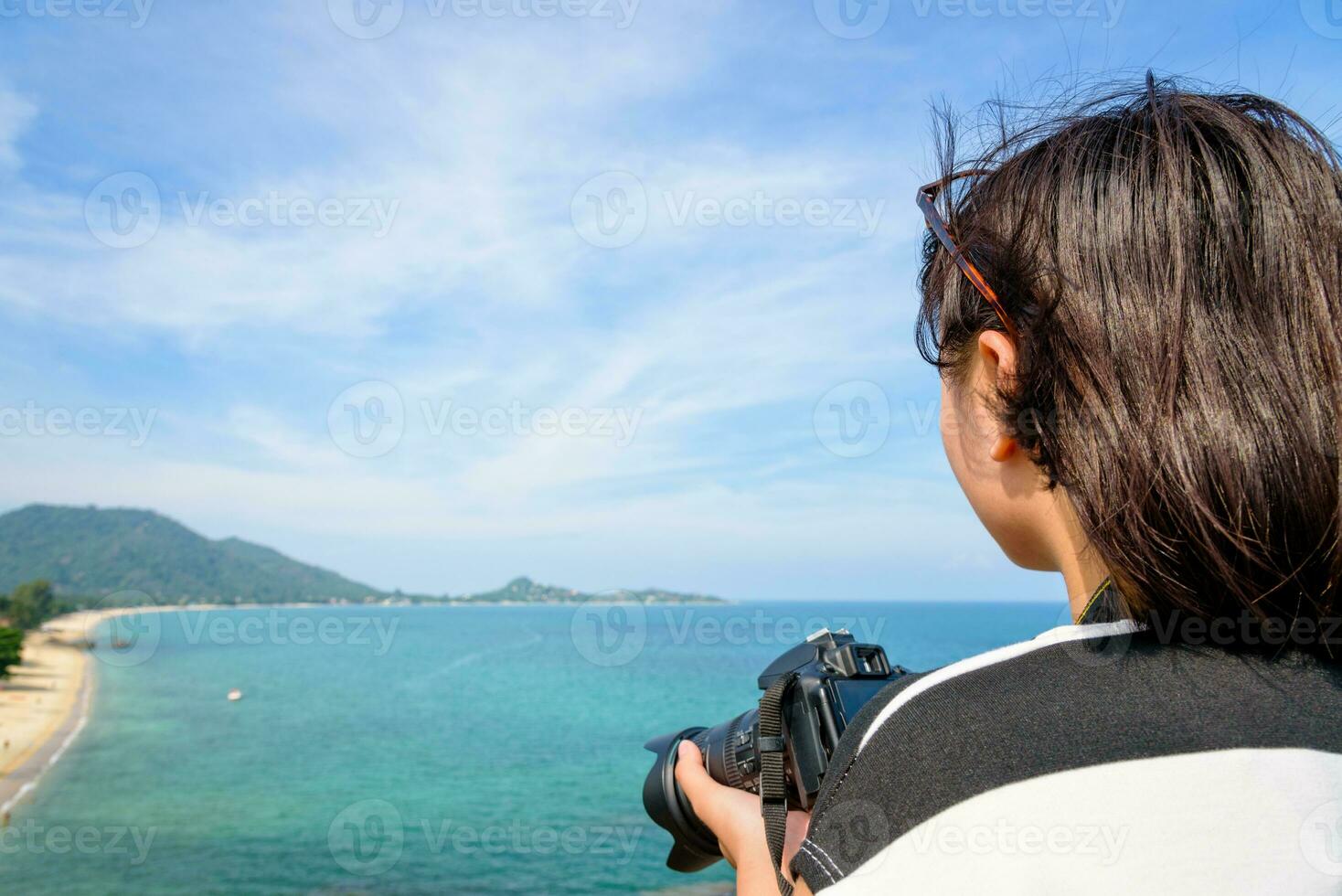 Teenage girl is holding camera on high photo