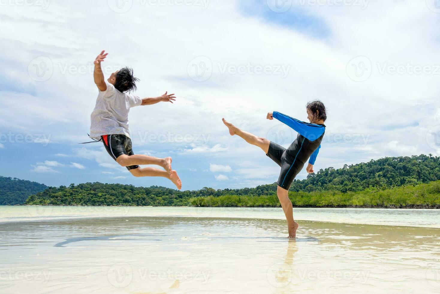 Couple play fun woman show kicking a man on the beach photo
