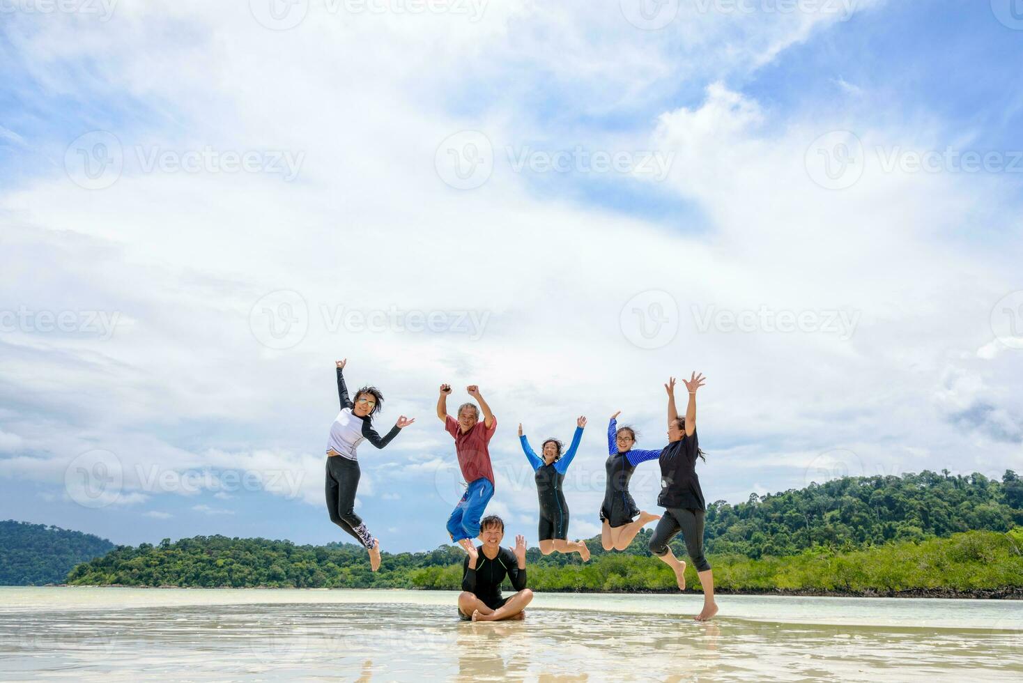 Happy family jumping together on the beach, Thailand photo