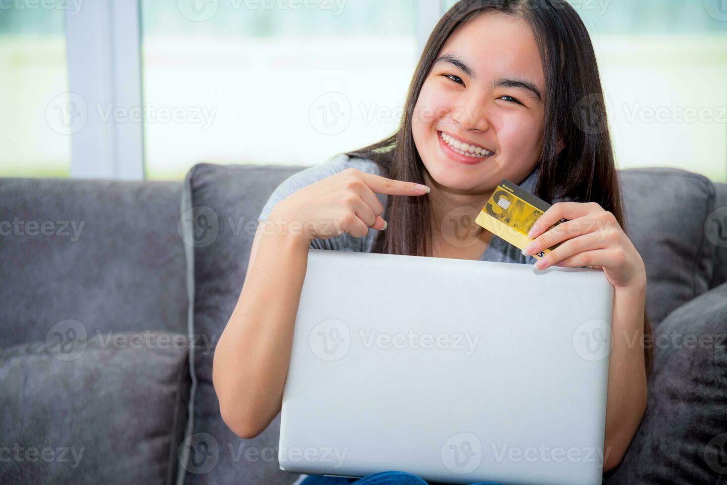 Girl smile pointing finger at credit card photo