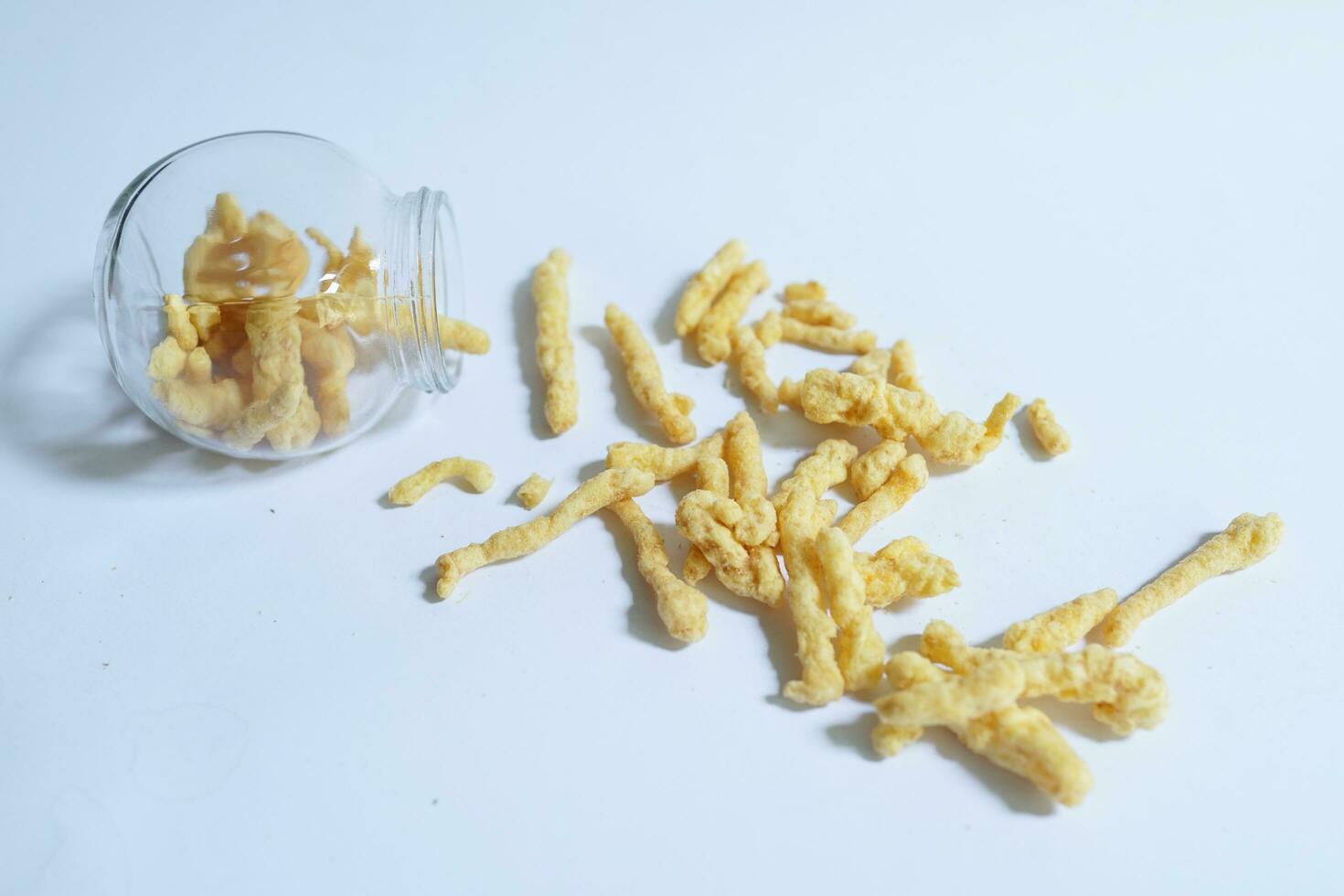 Crispy and delicious snacks made of oval shaped corn on a plain background photo