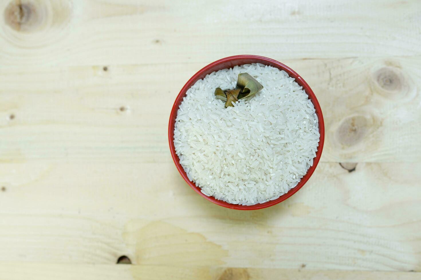Healthy food. red ceramic bowl with high carb rice on wooden background. Top view, high resolution product. photo