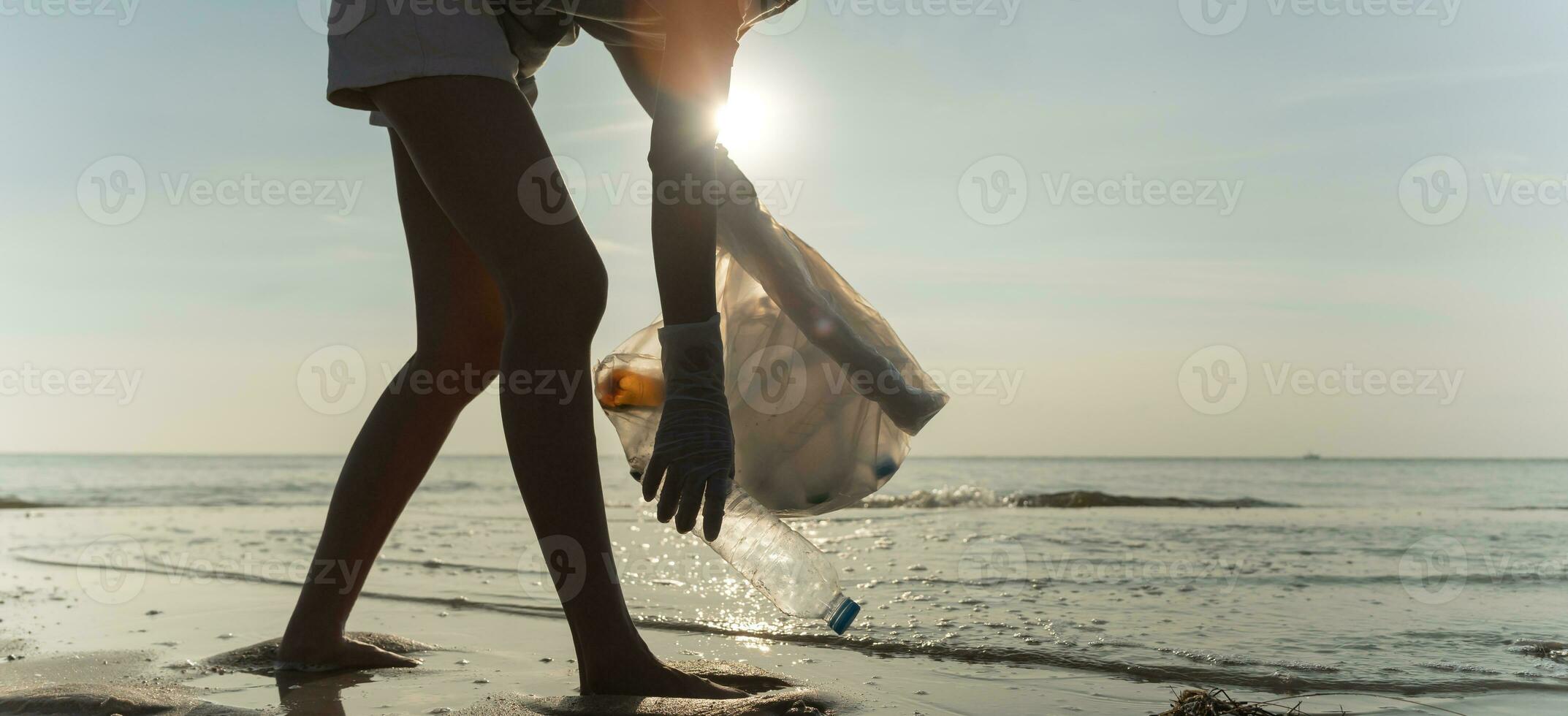 Save water. Volunteer pick up trash garbage at the beach and plastic bottles are difficult decompose prevent harm aquatic life. Earth, Environment, Greening planet, reduce global warming, Save world photo