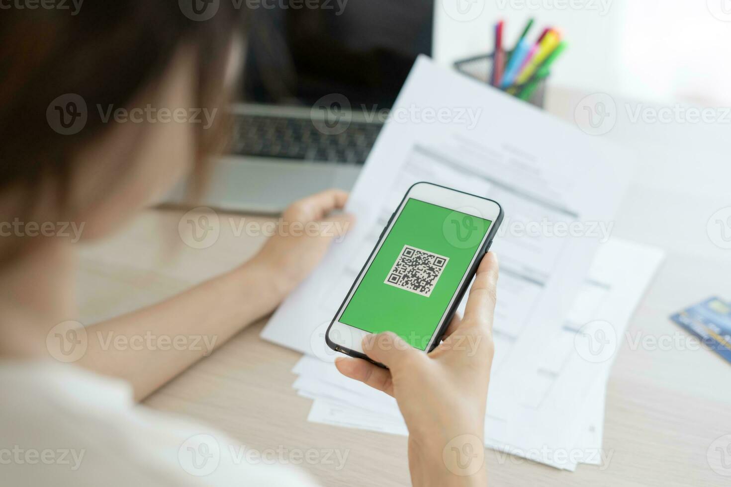 woman use phone scan barcode or QR codes to pay credit card bill after receiving document invoice. payment, receive, paying electricity, digital payments, technology, scanning, financial transactions photo