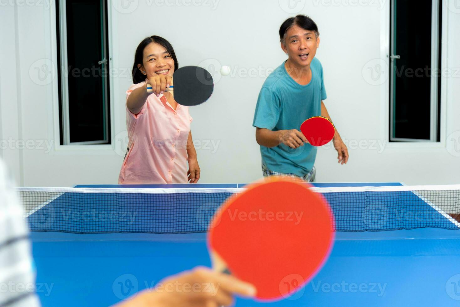 Couple fun playing table tennis indoor together photo