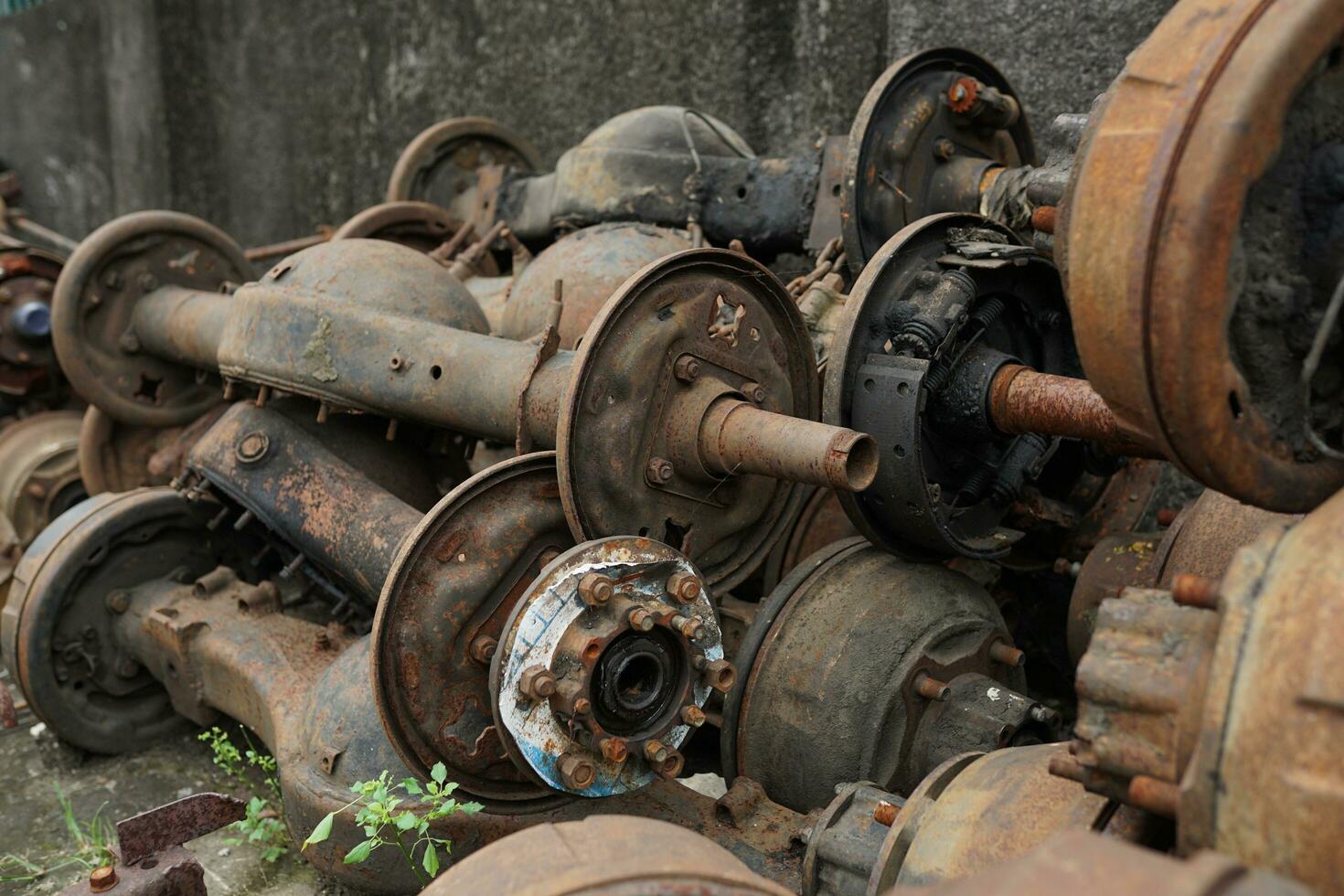 collection of broken metal truck chassis for sale at a junk metal shop photo