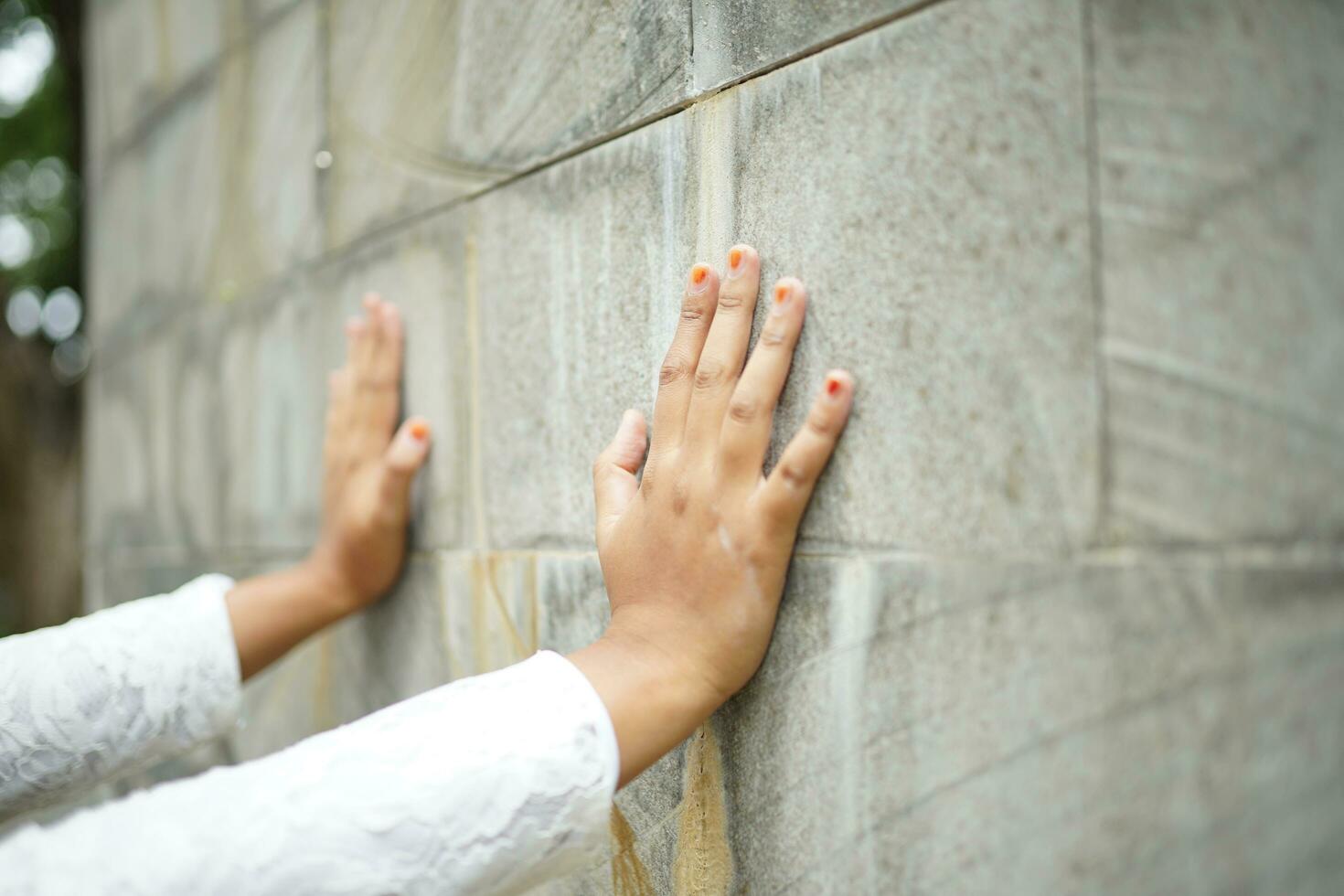 hands pushing against the stone wall with great force photo