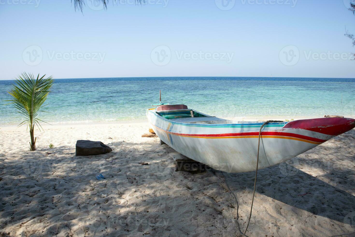 a traditional wooden boat sitting on top of a sandy beach photo