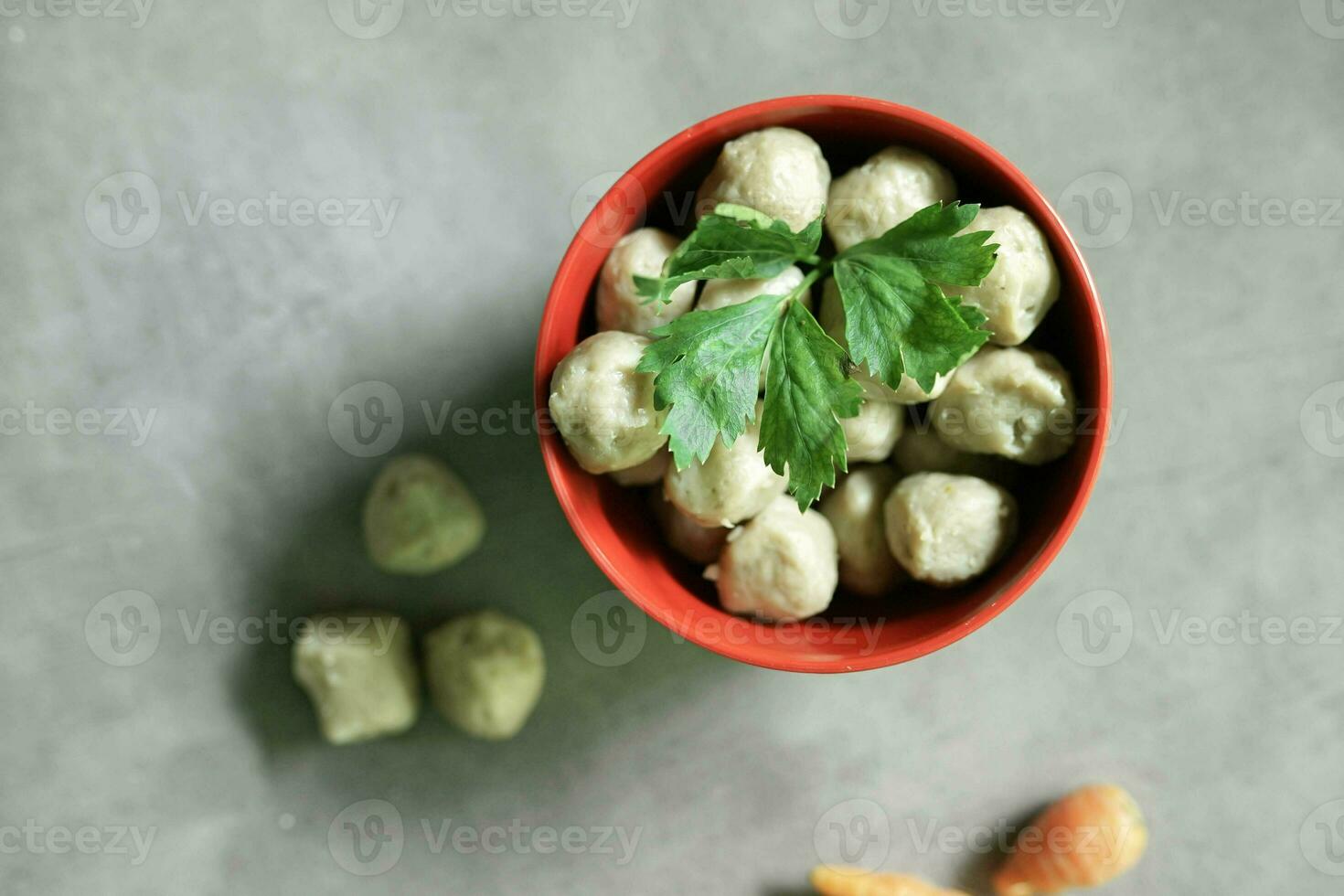 raw meatballs in a bowl with a concrete background photo