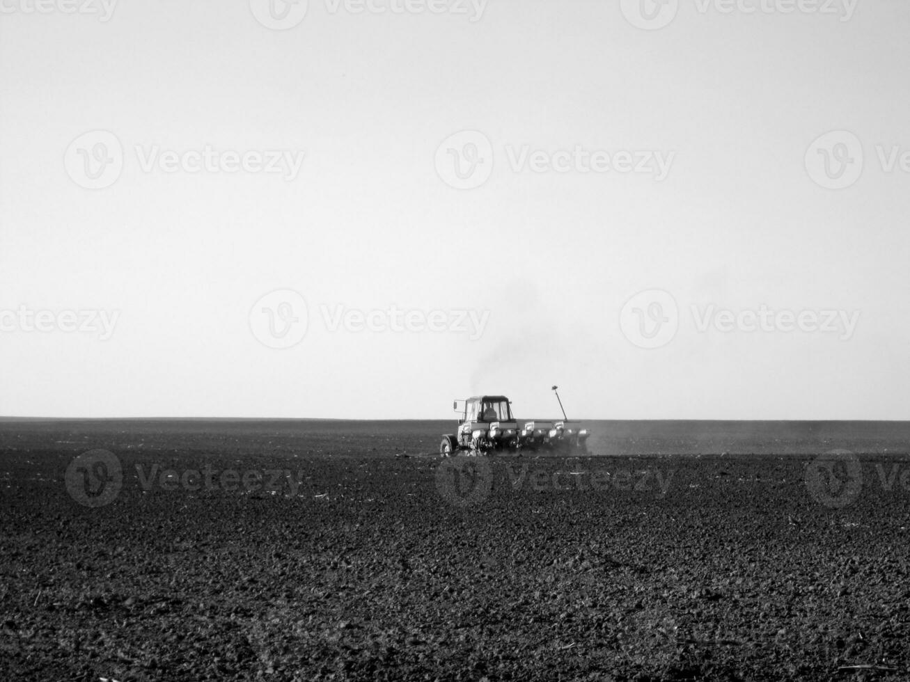 Plowed field by tractor in black soil on open countryside nature photo