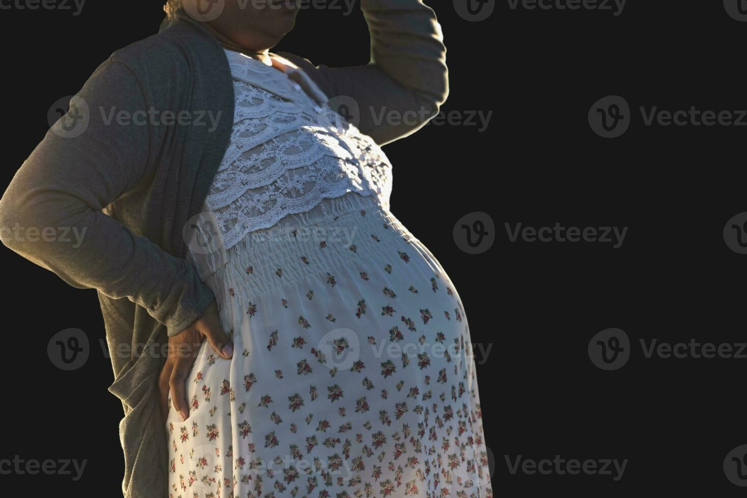 Happy pregnant woman stands rubbing her big belly lovingly at her home. Young woman's pregnancy enjoys future life Motherhood and pregnancy symbolize new life. Fertility The health of the fetus. photo
