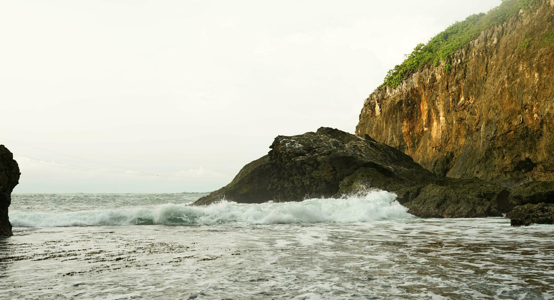 panorámico ver de el playa, coral montañas con olas en el tarde foto