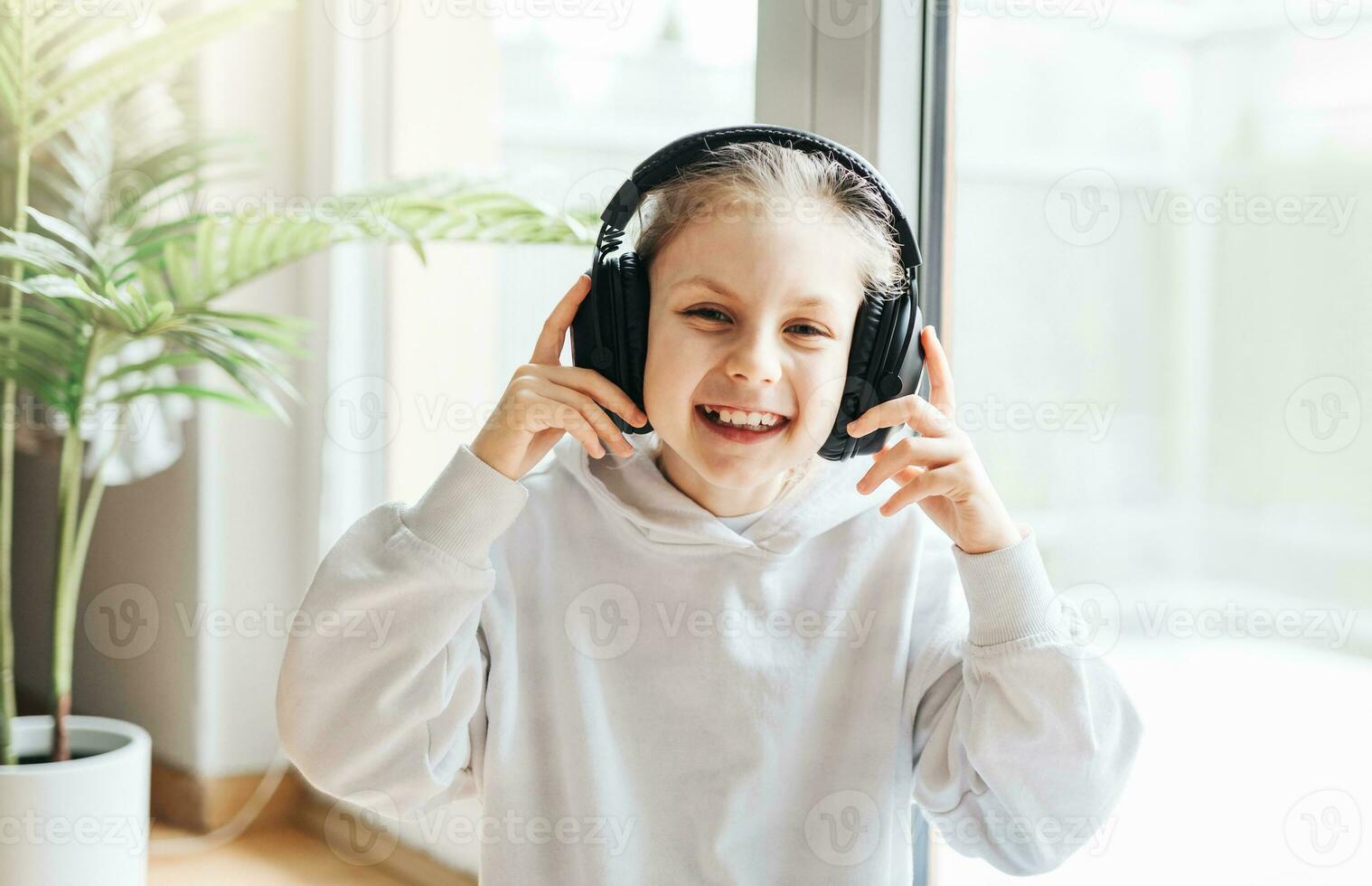 Cute little girl listening to music in headphones photo