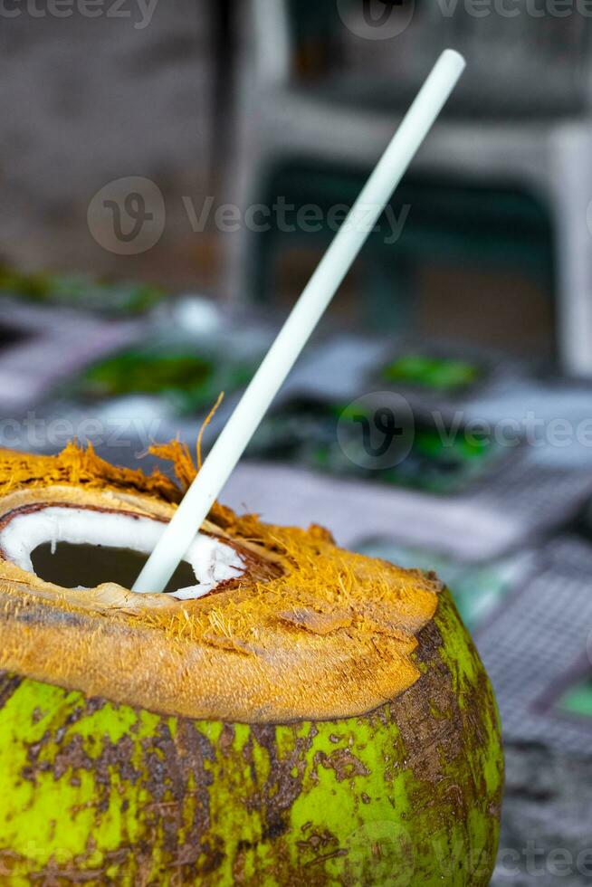 Coconut to drink with straw and small umbrella in Mexico. photo