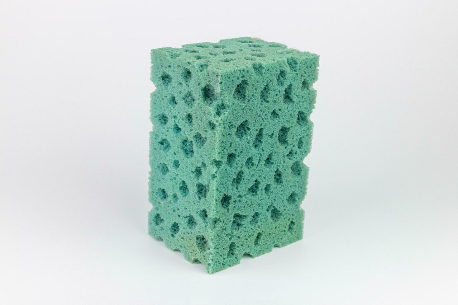 Green sponges for washing dishes on a white background closeup photo