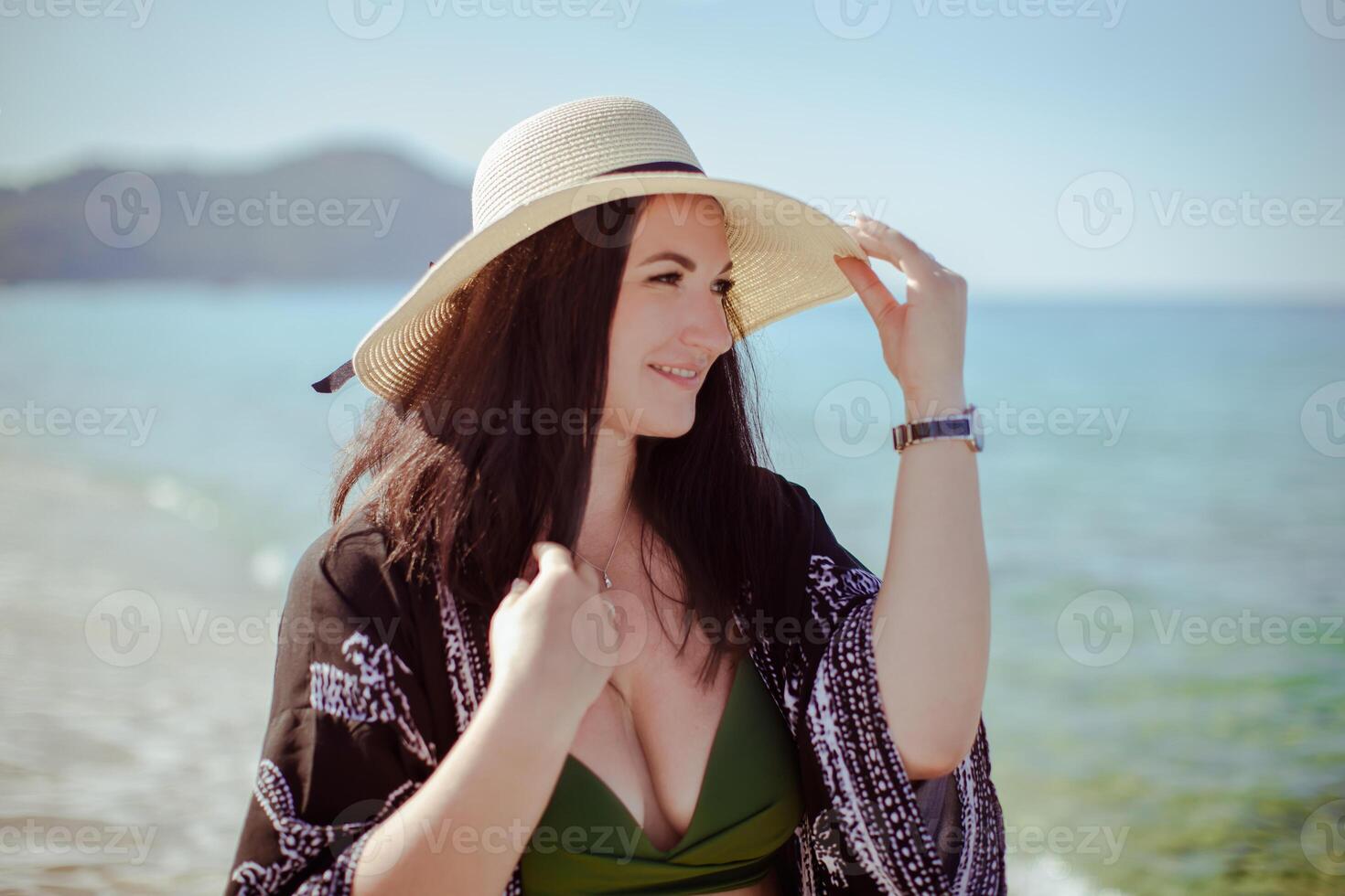 A girl in a hat on the background of the sea photo